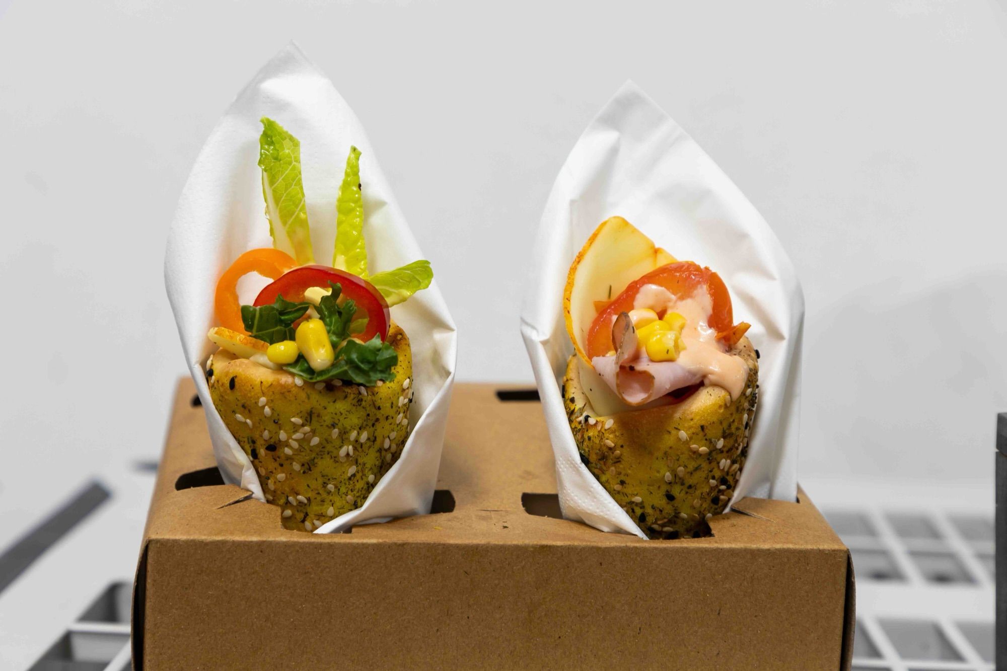 Two mini BreadKones wrapped in napkins in a kraft carry tray