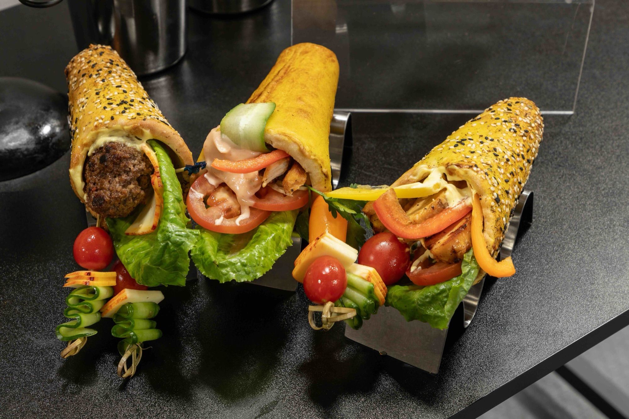 Large BreadKones filled with burger, chicken, and vegetables, with skewers
