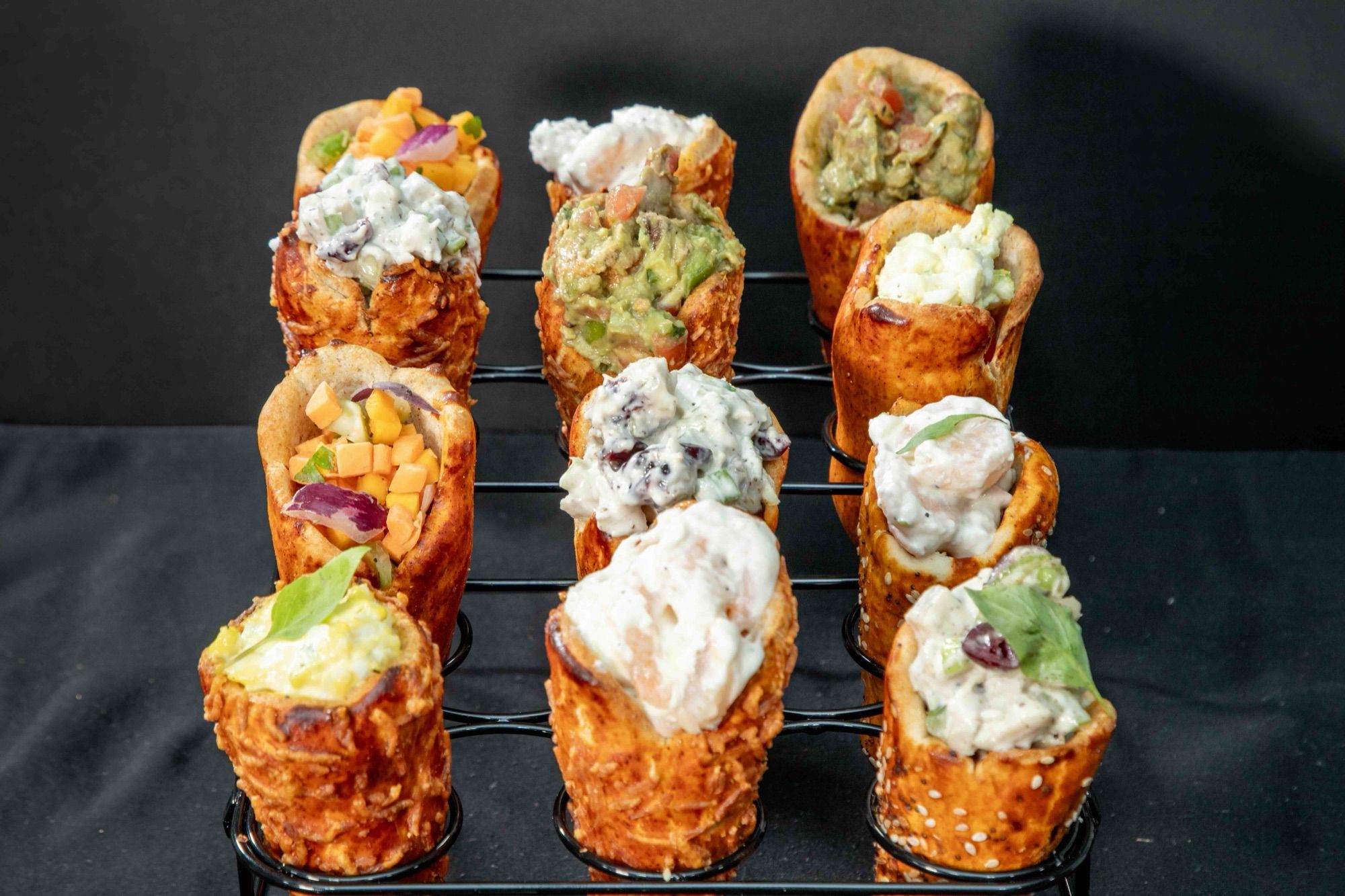 A rack of BreadKones filled with chicken, shrimp, tuna, and guacamole salads