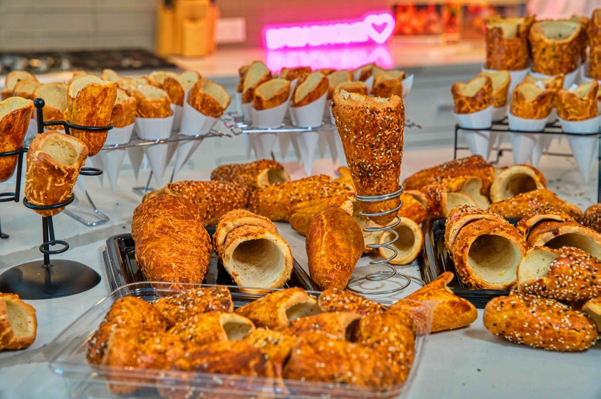 A BreadKone display: sesame cones in spiral holders and wire racks, with trays of empty cones in front