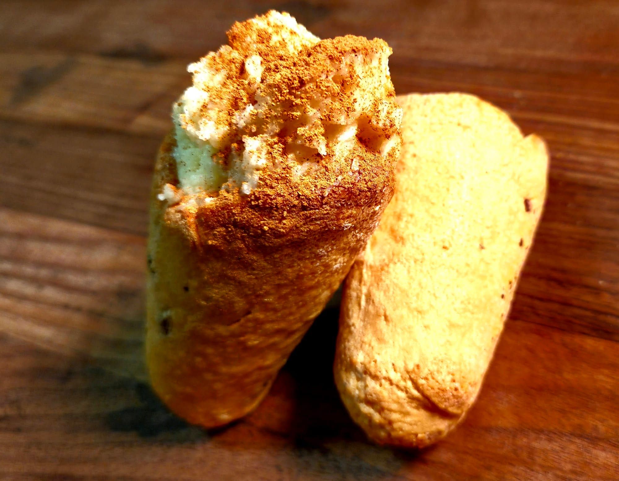 A filled BreadKone with a toasted cheese crust, leaning on a plain cone