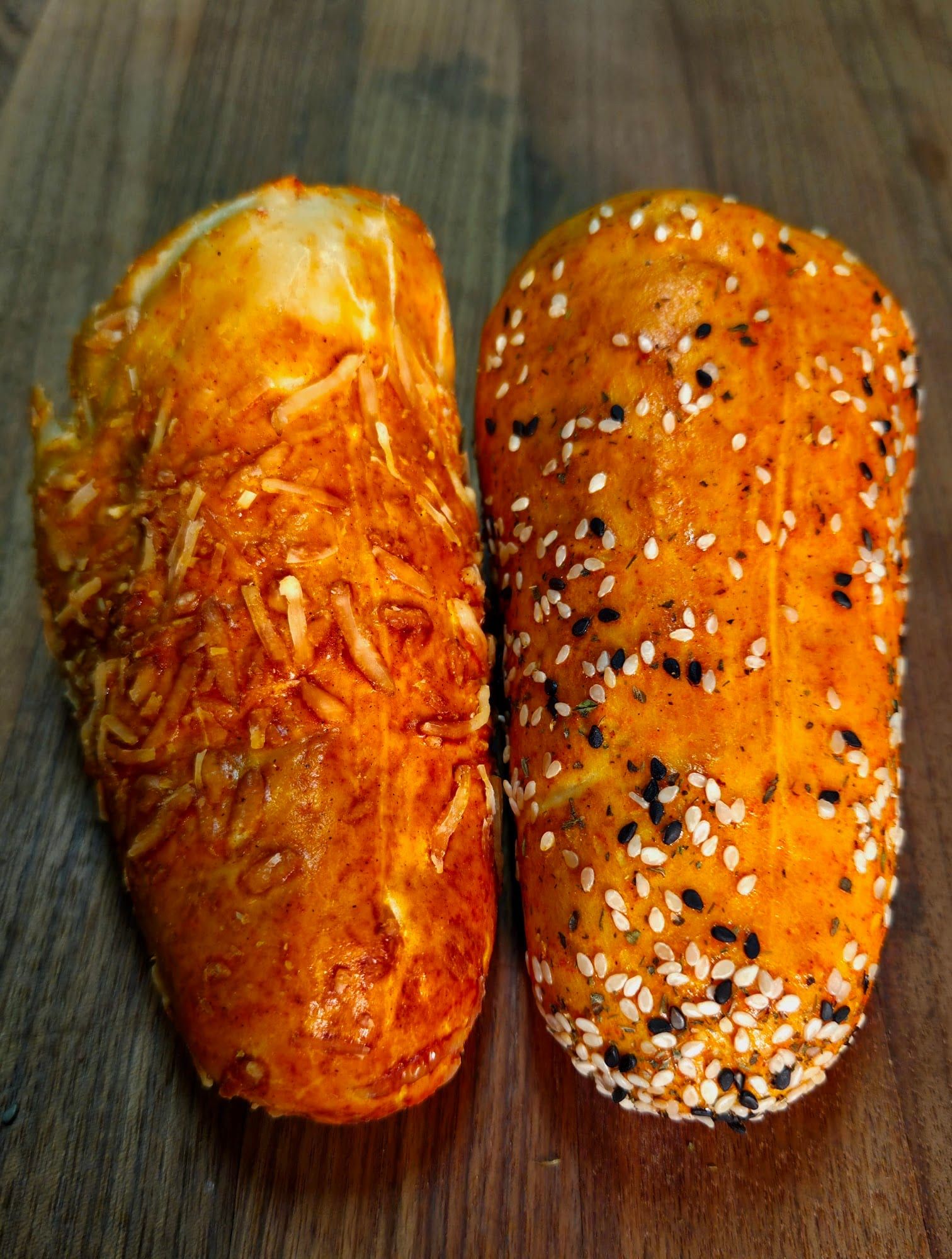 A Parmesan BreadKone and an Everything BreadKone side by side on a wooden board