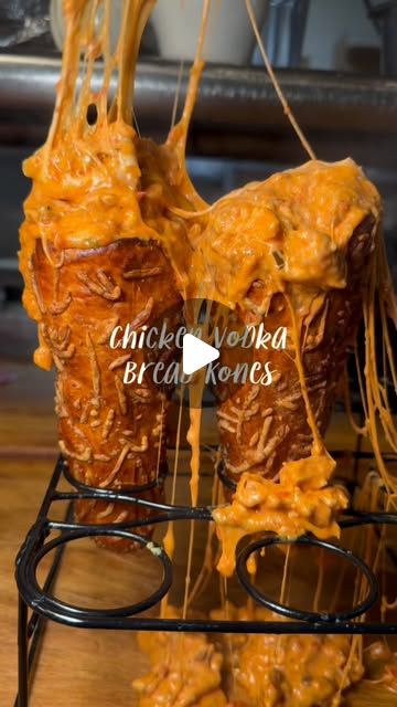 Chicken vodka BreadKones dripping with melted mozzarella in a wire stand