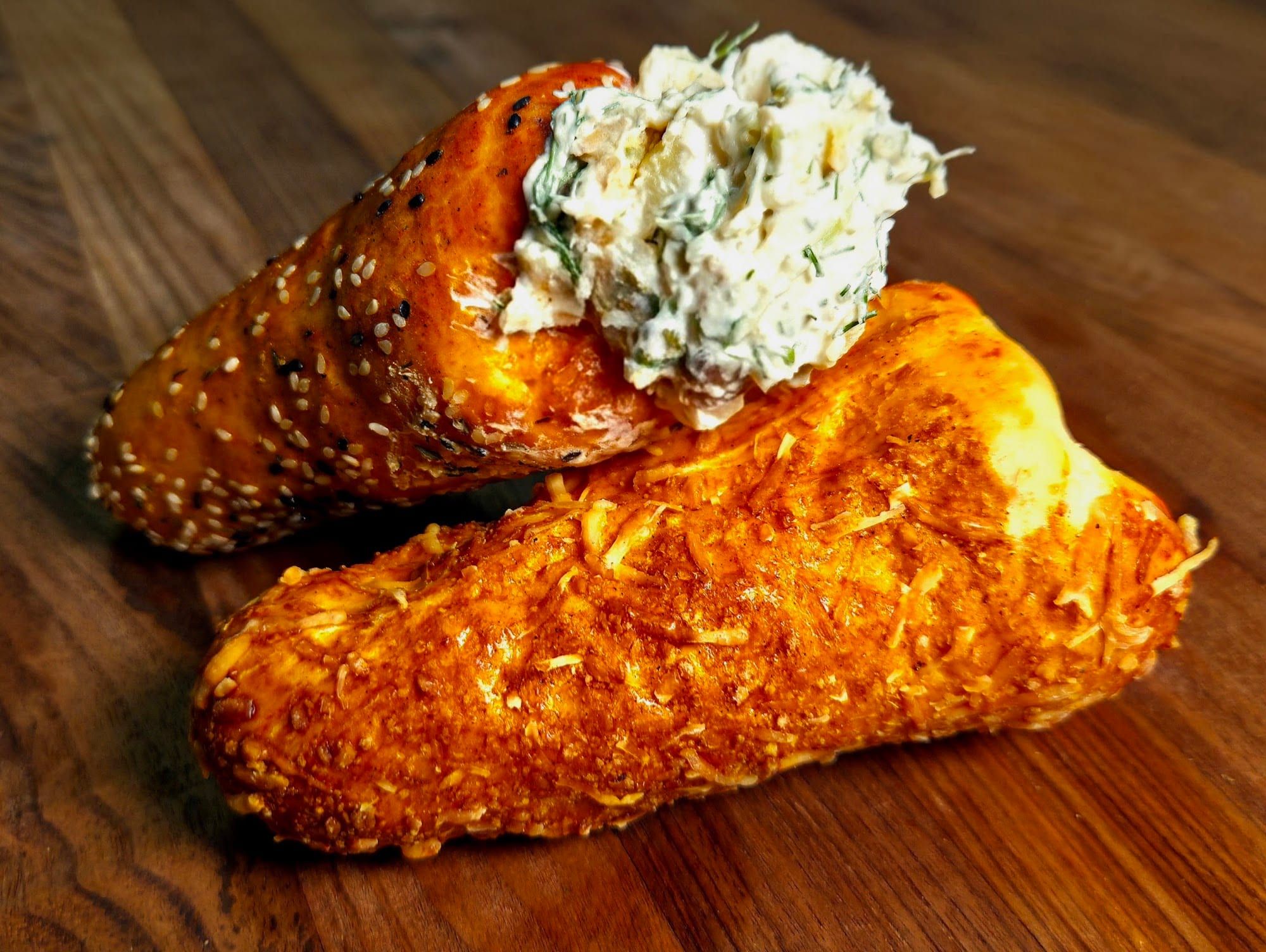 A sesame BreadKone filled with a creamy herb spread, resting on a Parmesan BreadKone