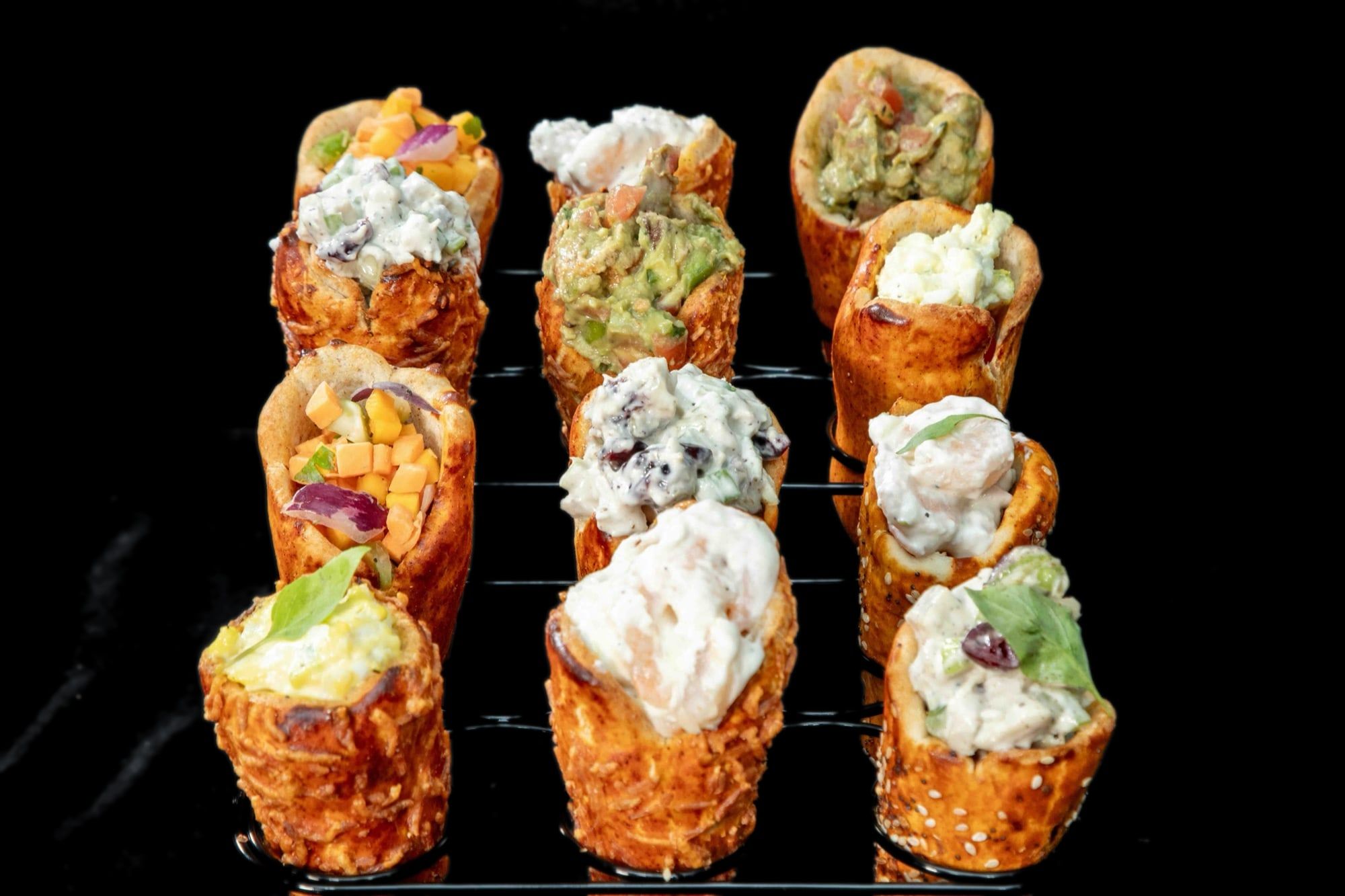 Mini BreadKones filled with chicken, shrimp, tuna, and guacamole salads in a wire rack