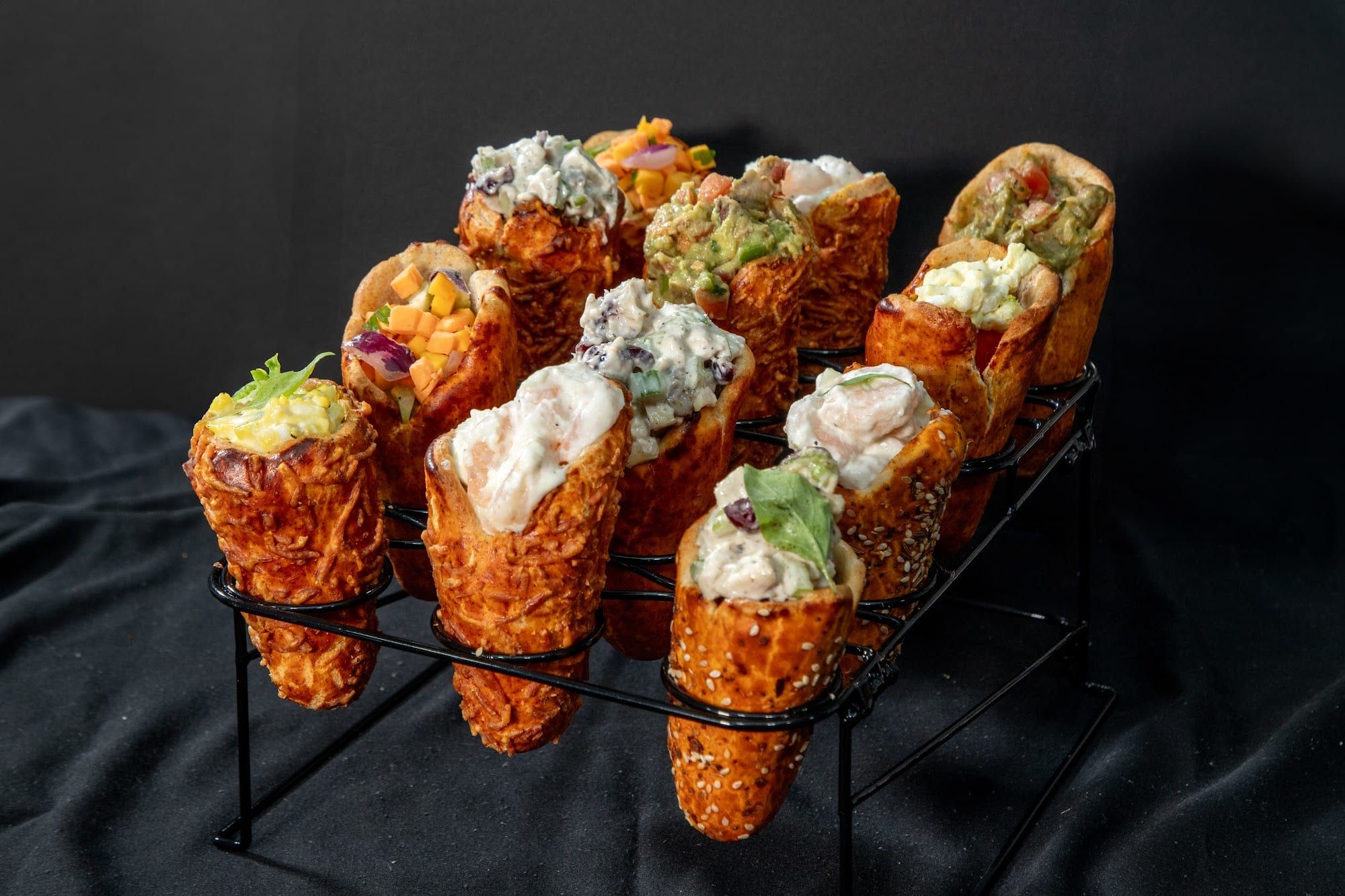A rack of Parmesan BreadKones filled with chicken, tuna, and vegetable salads